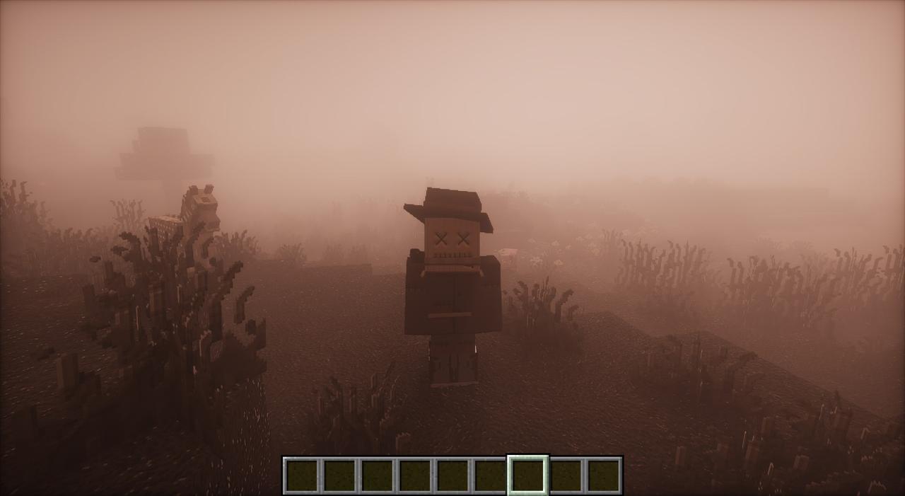 A lone figure in a hat standing far off in thick grey fog on a heath
